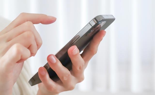 家族葬の青梅市葬儀社に電話でお問合せしようとしている人の手元。